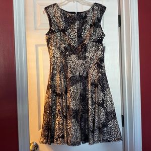 Black and white sleeveless dress with pleated skirt.